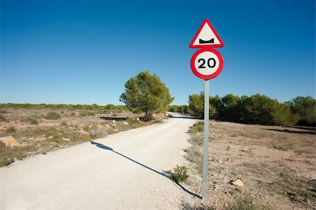 Warning sign on a potholed unpaved country road Stock Photo - Budget Royalty-Free & Subscription, Code: 400-05889446