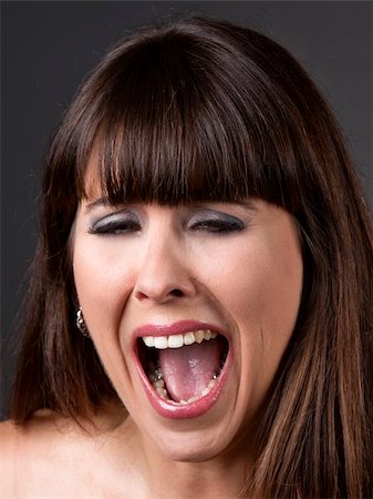 portrait screaming girl - Close-up portrait of a desperate woman shouting with something, against a grey background Stock Photo - Budget Royalty-Free & Subscription, Code: 400-05889937