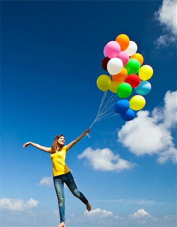 simsearch:400-06077546,k - Happy young woman holding colorful balloons and flying over a green meadow Stockbilder - Microstock & Abonnement, Bildnummer: 400-05889945