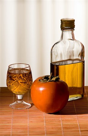 persimmon and a bottle of whiskey is on the table Photographie de stock - Aubaine LD & Abonnement, Code: 400-05880508