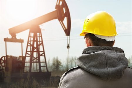 Oil worker in yellow helmet on of background the pump jack Stock Photo - Budget Royalty-Free & Subscription, Code: 400-05880819