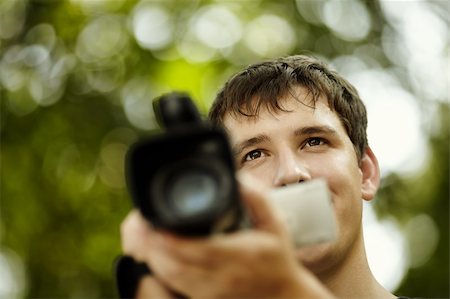 filmproduzent (männlich und weiblich) - teen with camcorder capturing, selective focus on eye, natural light Stockbilder - Microstock & Abonnement, Bildnummer: 400-05880822