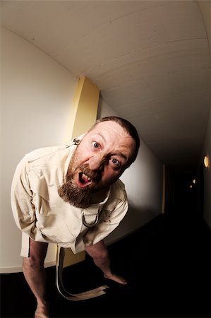 Photo of an insane man in his forties wearing a straitjacket standing in the hallway of an asylum.  Taken with a fisheye lens. Photographie de stock - Aubaine LD & Abonnement, Code: 400-05882148