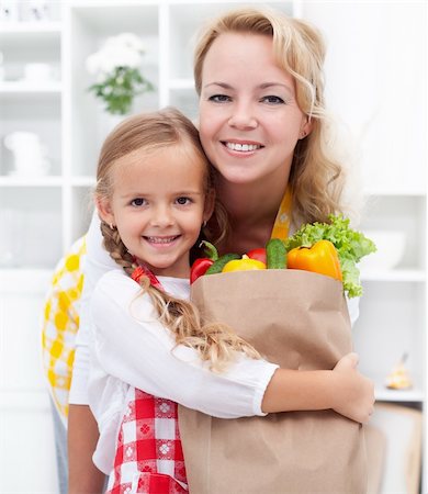 shopping bags in kitchen - Happy little girl and woman with the groceries bag wearing aprons Stock Photo - Budget Royalty-Free & Subscription, Code: 400-05882526