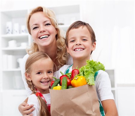 shopping bags in kitchen - Happy family with the grocery bag full of fresh vegetables - healthy life concept Stock Photo - Budget Royalty-Free & Subscription, Code: 400-05882527