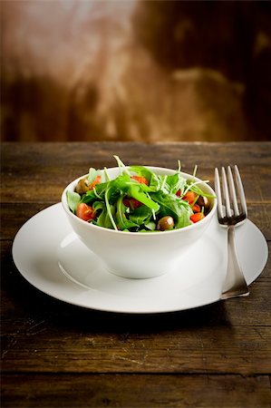 photo of deliciuos light salad with arugula and tomatoes in white bowl on wooden table Stockbilder - Microstock & Abonnement, Bildnummer: 400-05882638