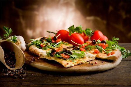 photo of delicious vegetarian pizza with arugula on wooden table Stockbilder - Microstock & Abonnement, Bildnummer: 400-05882630