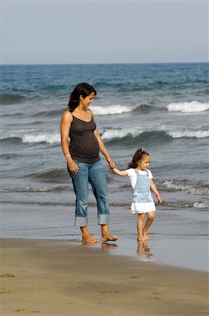 pregnant woman walking on beach - Pregnant woman walking with her child on the beach Stock Photo - Budget Royalty-Free & Subscription, Code: 400-05882823