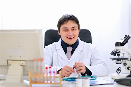 simsearch:400-04390415,k - Smiling medical doctor sitting at table in office Stock Photo - Budget Royalty-Free & Subscription, Code: 400-05883620
