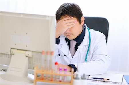 simsearch:400-04925813,k - Tired medical doctor working on computer at office Stock Photo - Budget Royalty-Free & Subscription, Code: 400-05883642