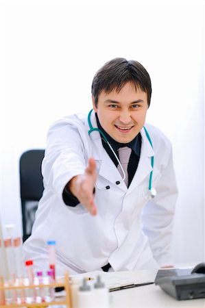 simsearch:400-04925813,k - Smiling medical doctor stretches out hand for handshake in office Stock Photo - Budget Royalty-Free & Subscription, Code: 400-05883651