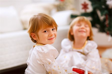 decor home new year - Portrait of happy girl playing with sister near Christmas tree Stock Photo - Budget Royalty-Free & Subscription, Code: 400-05883747