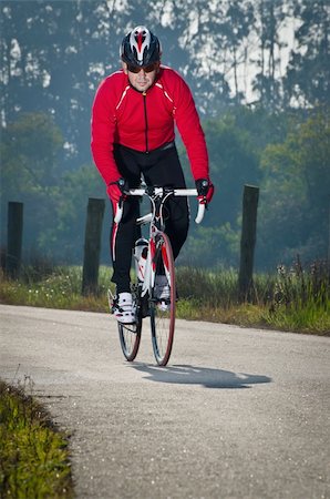 red and black bicycle - Man on road bike riding down open country road. Stock Photo - Budget Royalty-Free & Subscription, Code: 400-05894123