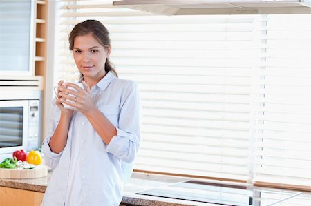 simsearch:400-04335902,k - Serene woman holding a cup of tea in her kitchen Photographie de stock - Aubaine LD & Abonnement, Code: 400-05894598