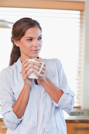 simsearch:400-04335902,k - Portrait of a woman holding a cup of coffee in her kitchen Stock Photo - Budget Royalty-Free & Subscription, Code: 400-05894592