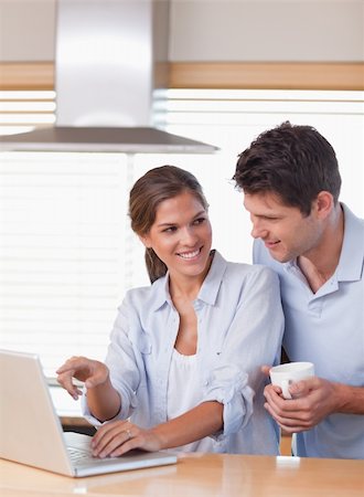 simsearch:400-05749531,k - Portrait of a couple using a laptop while having tea in their kitchen Stock Photo - Budget Royalty-Free & Subscription, Code: 400-05894660
