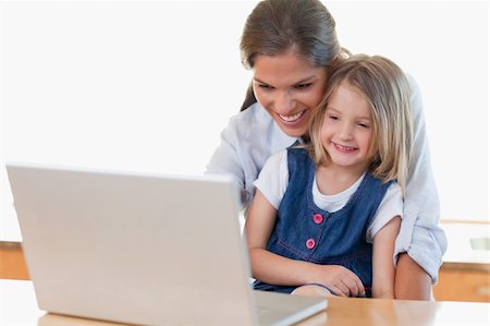 simsearch:400-04044122,k - Mother and her daughter using a notebook in their kitchen Stock Photo - Budget Royalty-Free & Subscription, Code: 400-05894684