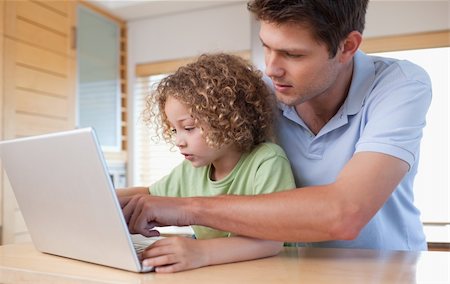 simsearch:400-05749726,k - Boy and his father using a laptop in a kitchen Foto de stock - Super Valor sin royalties y Suscripción, Código: 400-05894694