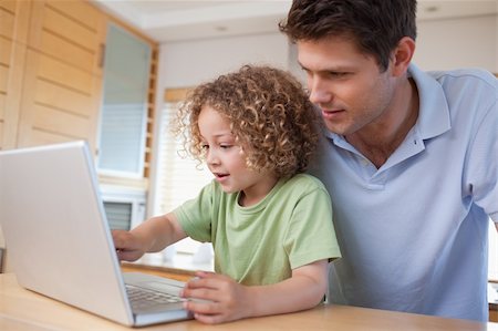 simsearch:400-05749726,k - Boy and his father using a notebook in their kitchen Foto de stock - Super Valor sin royalties y Suscripción, Código: 400-05894695