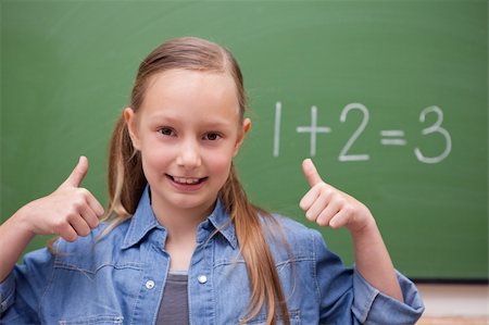 simsearch:625-01250891,k - Schoolgirl with the thumbs up in front of a backboard Fotografie stock - Microstock e Abbonamento, Codice: 400-05894744