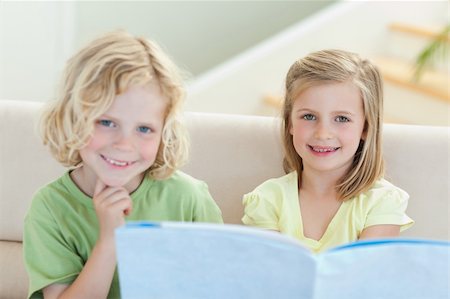 simsearch:400-05751566,k - Siblings on the couch reading magazine together Stock Photo - Budget Royalty-Free & Subscription, Code: 400-05894892