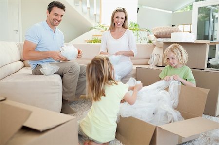 Family unpacking cardboard box in the living room together Stock Photo - Budget Royalty-Free & Subscription, Code: 400-05894920