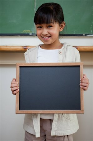 Portrait of a girl holding a school slate in a classroom Stock Photo - Budget Royalty-Free & Subscription, Code: 400-05895114