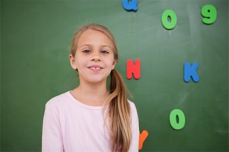 Schoolgirl posing in front of a blackboard in a classroom Stock Photo - Budget Royalty-Free & Subscription, Code: 400-05895121
