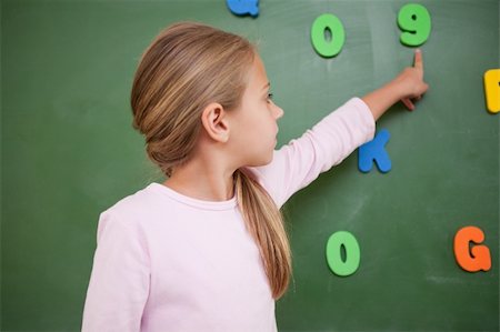 Schoolgirl pointing at a number on a blackboard Stock Photo - Budget Royalty-Free & Subscription, Code: 400-05895123