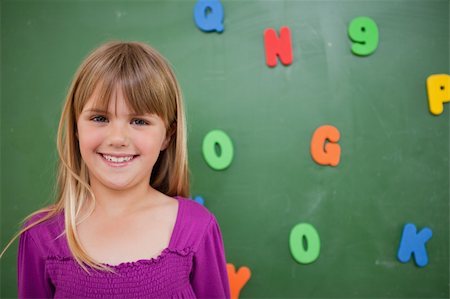 Little schoolgirl posing in front of a blackboard in a classroom Stock Photo - Budget Royalty-Free & Subscription, Code: 400-05895130