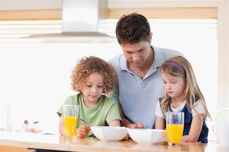 simsearch:400-04791807,k - Father with his children having breakfast in their kitchen Photographie de stock - Aubaine LD & Abonnement, Code: 400-05895133