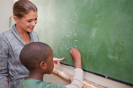 Cute teacher and a pupil making an addition on a blackboard Stock Photo - Budget Royalty-Free & Subscription, Code: 400-05895177