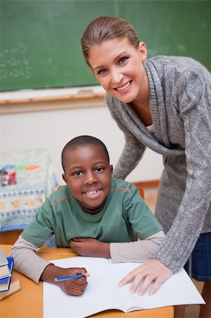 simsearch:614-02242541,k - Portrait of a teacher explaining something to a smiling schoolboy in a classroom Foto de stock - Royalty-Free Super Valor e Assinatura, Número: 400-05895196