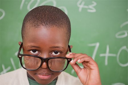 simsearch:400-05896550,k - Schoolboy looking over his glasses in front of a blackboard Stock Photo - Budget Royalty-Free & Subscription, Code: 400-05895215