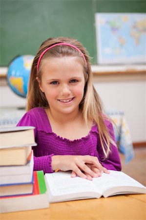 simsearch:400-08429355,k - Portrait of young schoolgirl reading a book in a classroom Photographie de stock - Aubaine LD & Abonnement, Code: 400-05895417