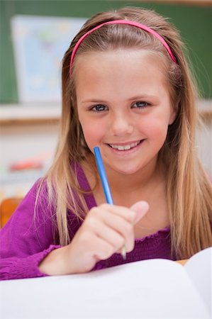 simsearch:400-05329645,k - Portrait of a little schoolgirl writing on a book in a classroom Stock Photo - Budget Royalty-Free & Subscription, Code: 400-05895483