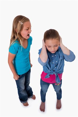 sibling sad - Portrait of an unhappy girl screaming at her friend against a white background Stock Photo - Budget Royalty-Free & Subscription, Code: 400-05895546