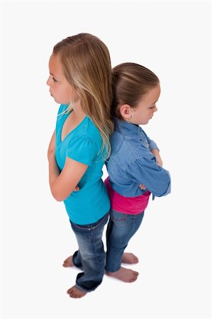 sisters fighting - Portrait of two girls standing back to back against a white background Stock Photo - Budget Royalty-Free & Subscription, Code: 400-05895549