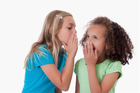simsearch:400-03926791,k - Young girl whispering a secret to her friend against a white background Fotografie stock - Microstock e Abbonamento, Codice: 400-05895577
