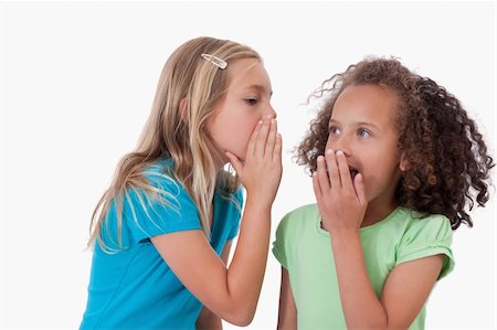 simsearch:400-05108874,k - Cute girl whispering a secret to her friend against a white background Photographie de stock - Aubaine LD & Abonnement, Code: 400-05895578