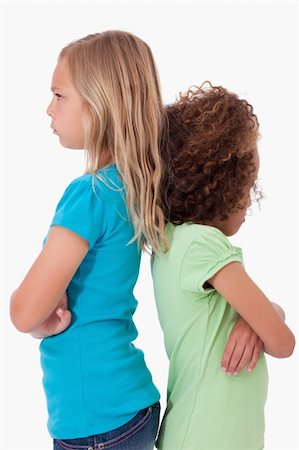 sisters fighting - Portrait of unhappy girls standing back to back against a white background Stock Photo - Budget Royalty-Free & Subscription, Code: 400-05895579