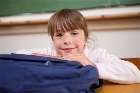 Cute schoolgirl posing with a bag in a classroom Stock Photo - Budget Royalty-Free & Subscription, Code: 400-05895618