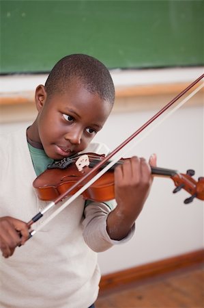 Portrait of a schoolboy playing the violin in a classroom Stock Photo - Budget Royalty-Free & Subscription, Code: 400-05895624