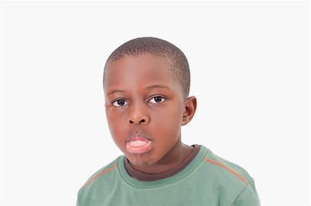 Boy sticking out his tongue against a white background Stock Photo - Budget Royalty-Free & Subscription, Code: 400-05895643