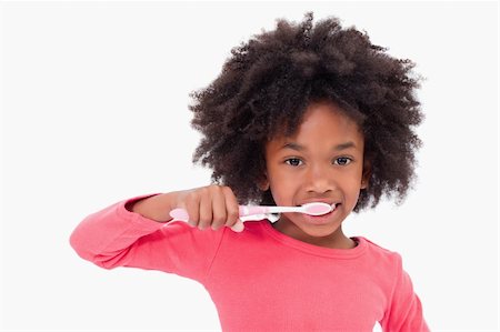 simsearch:400-06327889,k - Girl brushing her teeth against a white background Photographie de stock - Aubaine LD & Abonnement, Code: 400-05895686