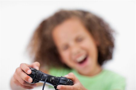 Smiling girl playing a video game against a white background Stock Photo - Budget Royalty-Free & Subscription, Code: 400-05895731