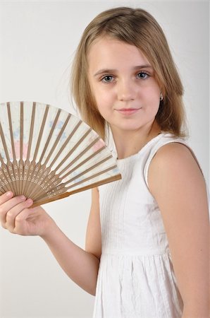 portrait of a beautiful elementary age girl fanning herself Photographie de stock - Aubaine LD & Abonnement, Code: 400-05896121