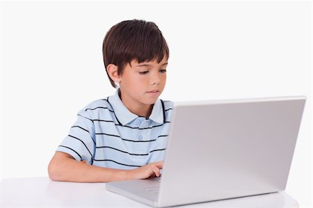 simsearch:400-04129482,k - Boy using a laptop against a white background Photographie de stock - Aubaine LD & Abonnement, Code: 400-05896299