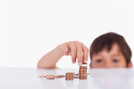 Young boy counting his change against a white background Stock Photo - Budget Royalty-Free & Subscription, Code: 400-05896307