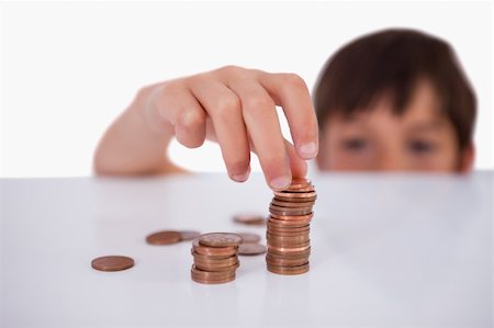 Little boy counting his change against a white background Stock Photo - Budget Royalty-Free & Subscription, Code: 400-05896308